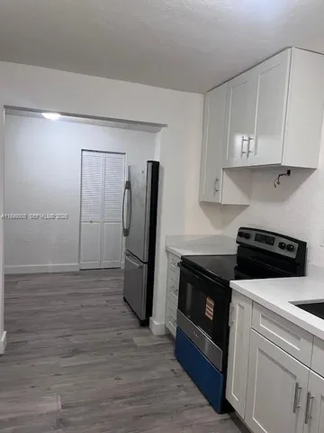 a kitchen with a refrigerator sink and cabinets
