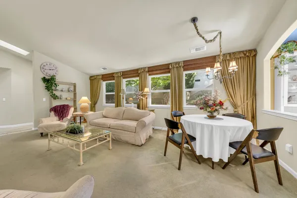 a living room with furniture a table and a floor to ceiling window