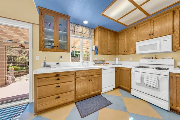 a kitchen with cabinets wooden floor and a window