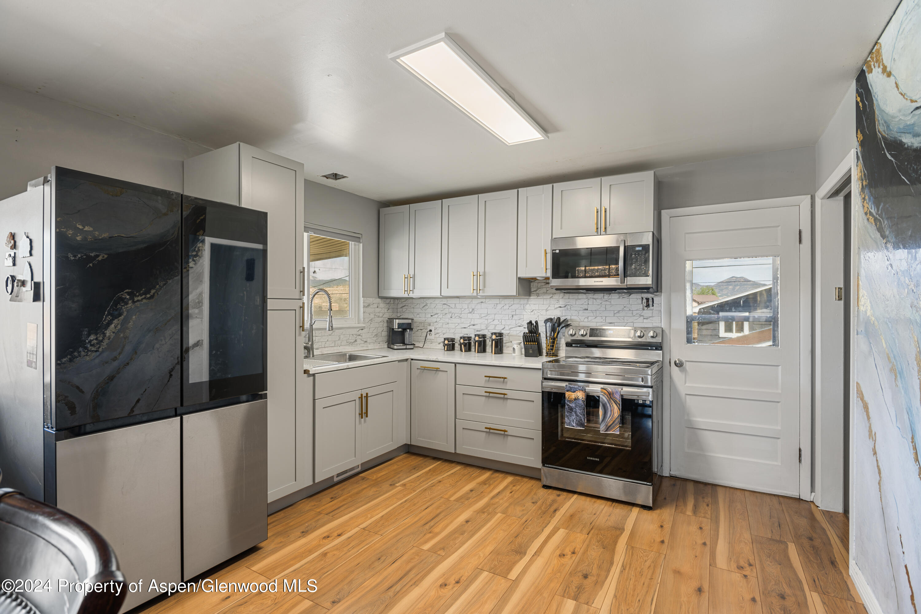 1100 Clarkson Avenue Rifle, CO 81650 - Photo 5 of 13 a kitchen with stainless steel appliances granite countertop a refrigerator and a stove top oven