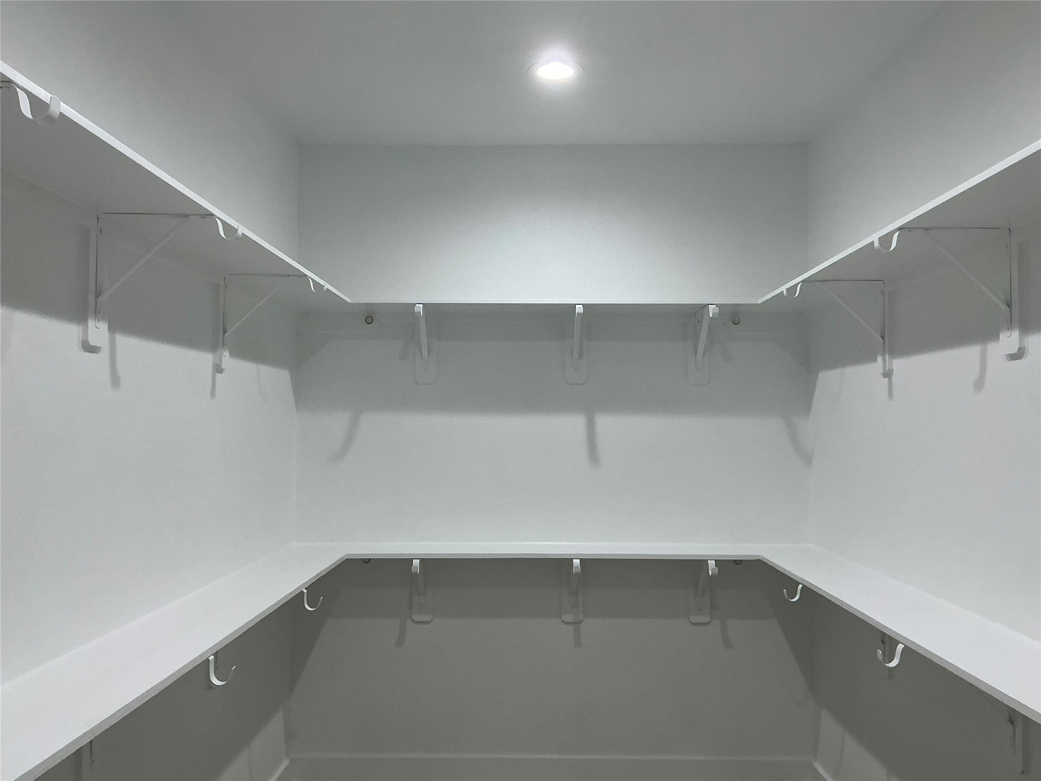 471 Buffalo Trail Angleton, TX 77515 - Photo 25 of 35 Spacious walk-in closet with ample shelving and hanging space, featuring a clean, modern design and bright overhead lighting.