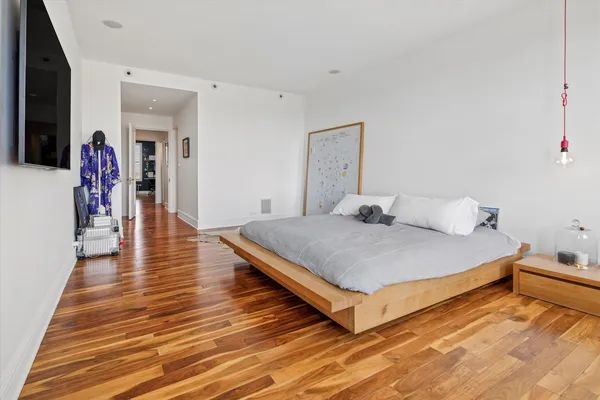 a bedroom with a bed and wooden floor
