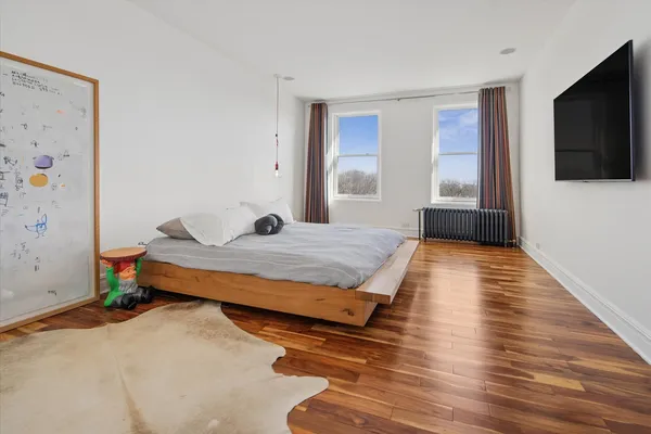 a bedroom with a bed and flat screen tv