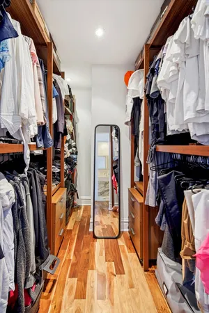 a view of walk in closet with clothes and shoes