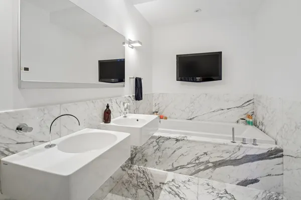 a bathroom with a sink and a flat screen tv
