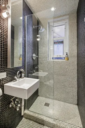 a bathroom with a sink a toilet a mirror and shower