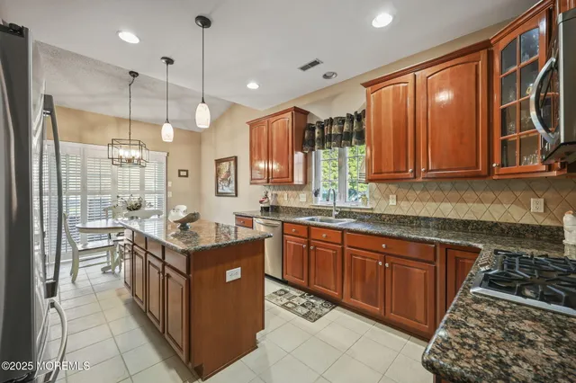 a kitchen with stainless steel appliances granite countertop a sink stove and refrigerator