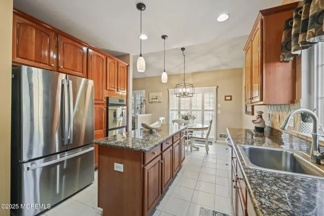 a kitchen with stainless steel appliances granite countertop wooden cabinets a sink and a stove