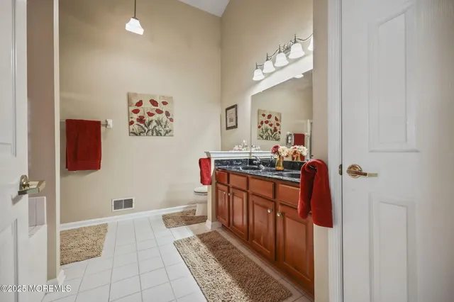 a spacious bedroom with a large bed and a chandelier