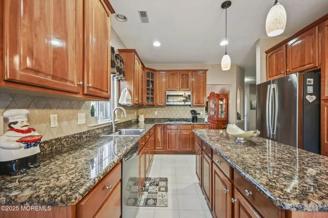 a kitchen with a refrigerator a sink and wooden cabinets