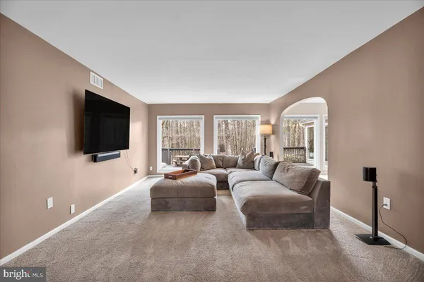 a living room with furniture a flat screen tv and a large window