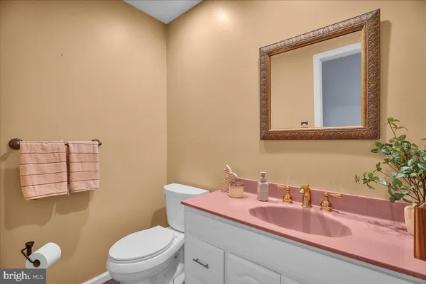 a bathroom with a granite countertop sink mirror and toilet