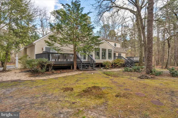 a front view of a house with a yard covered with snow and trees