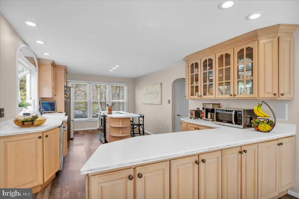 a kitchen that has a lot of white furniture and wooden floor