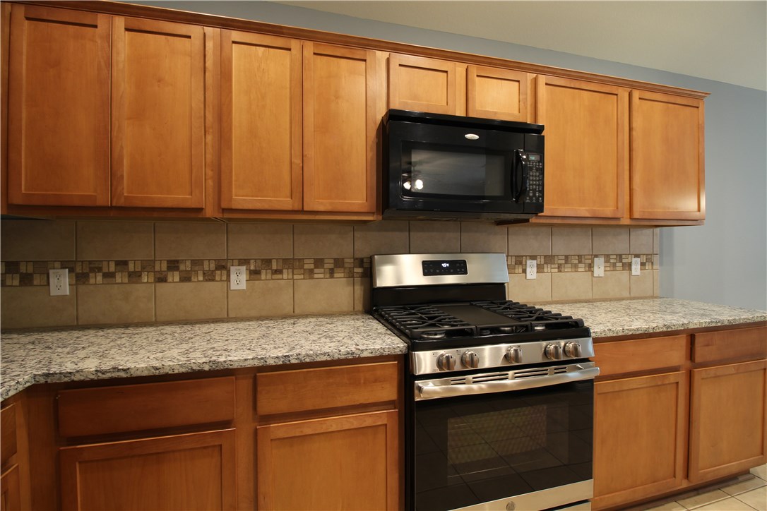 11505 Oltons Bluff Cove Austin, TX 78754 - Photo 6 of 21 a kitchen with granite countertop wood cabinets and stainless steel appliances