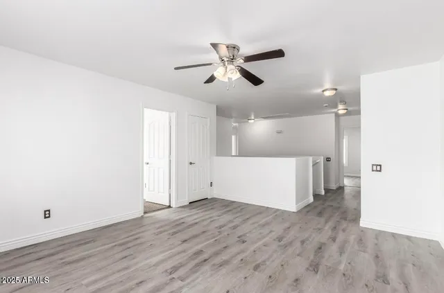 a view of empty room with wooden floor
