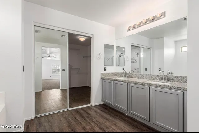 a bathroom with a granite countertop sink shower and a mirror