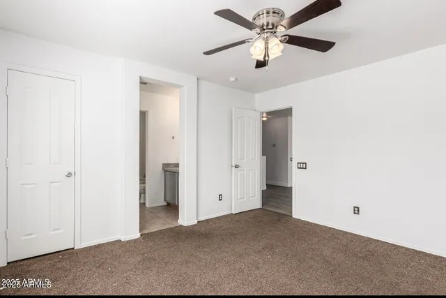 a view of an empty room with a ceiling fan