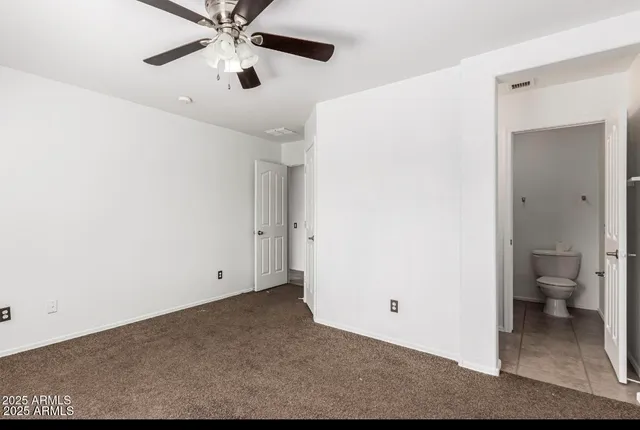 a view of a room with a ceiling fan and bathroom