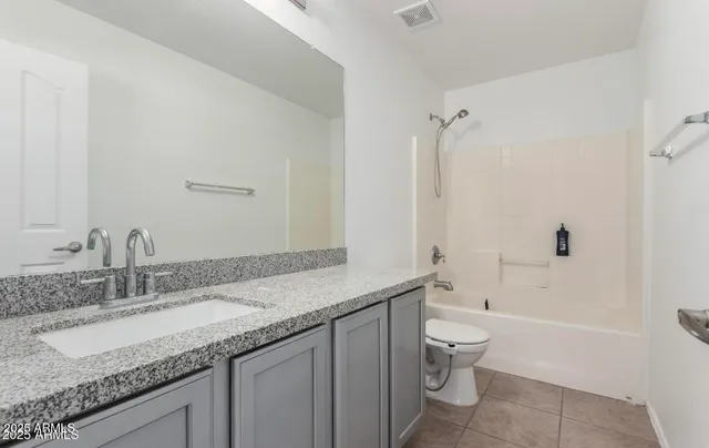 a bathroom with a granite countertop sink a toilet and bathtub