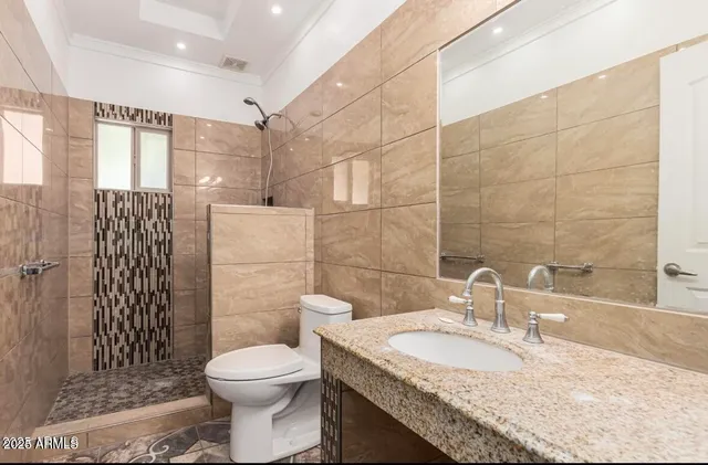 a bathroom with a granite countertop toilet sink shower and mirror