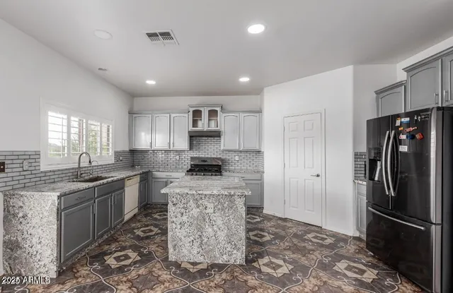 a kitchen with a refrigerator sink and stainless steel appliances