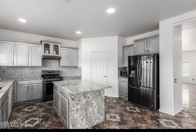 a kitchen with stainless steel appliances granite countertop a refrigerator stove and cabinets