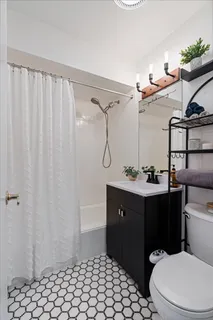 a bathroom with a sink vanity mirror and toilet