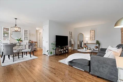 a living room with furniture flat screen tv and wooden floor