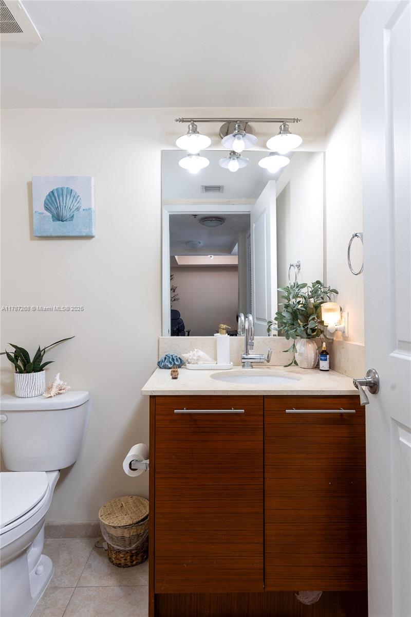 2681 North Flamingo Road, Unit TH4S Sunrise, FL 33323 - Photo 6 of 27 a bathroom with a toilet sink and mirror