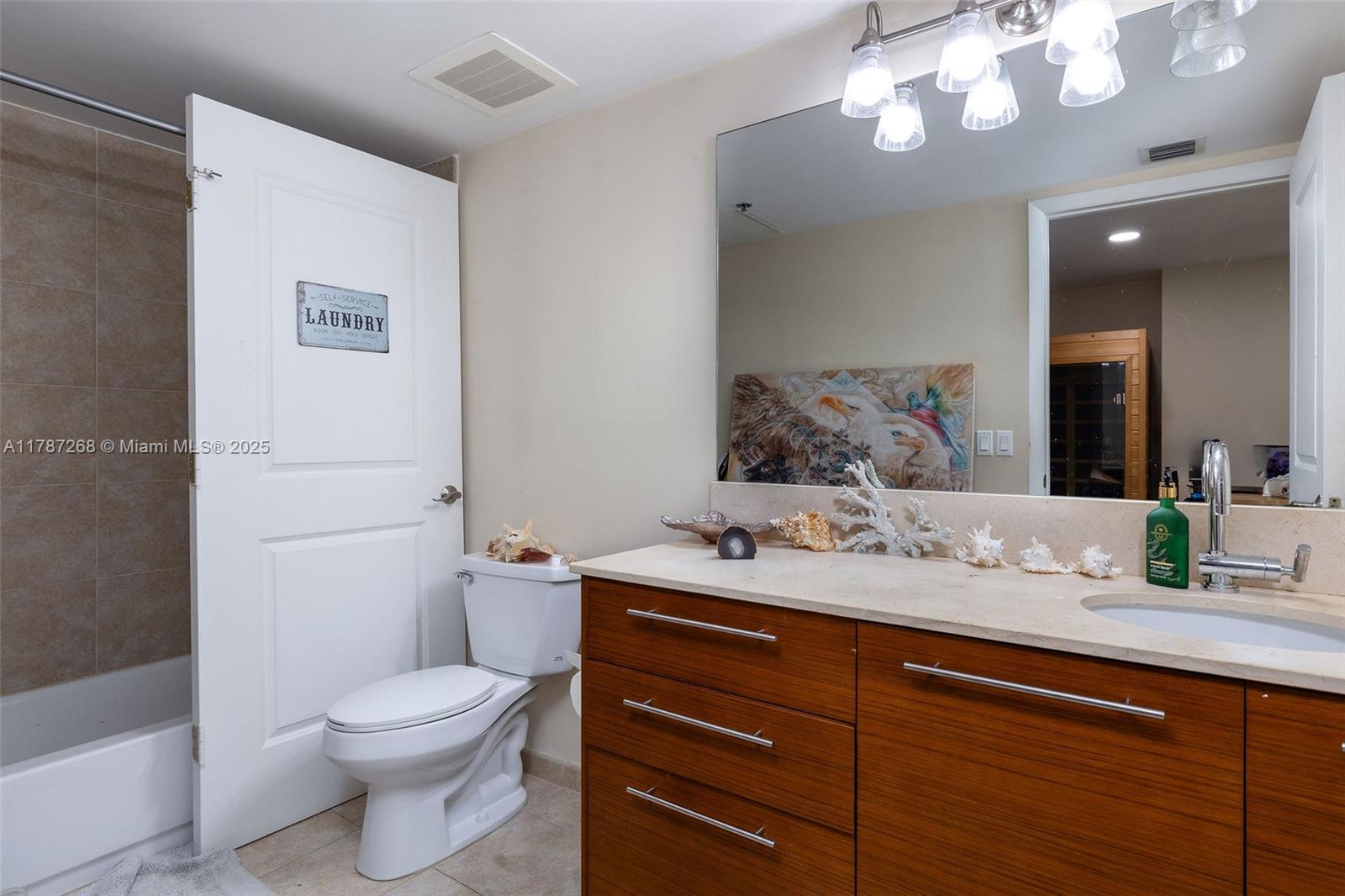2681 North Flamingo Road, Unit TH4S Sunrise, FL 33323 - Photo 8 of 27 a bathroom with a toilet a sink and mirror