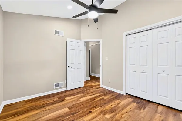 an empty room with window and ceiling fan
