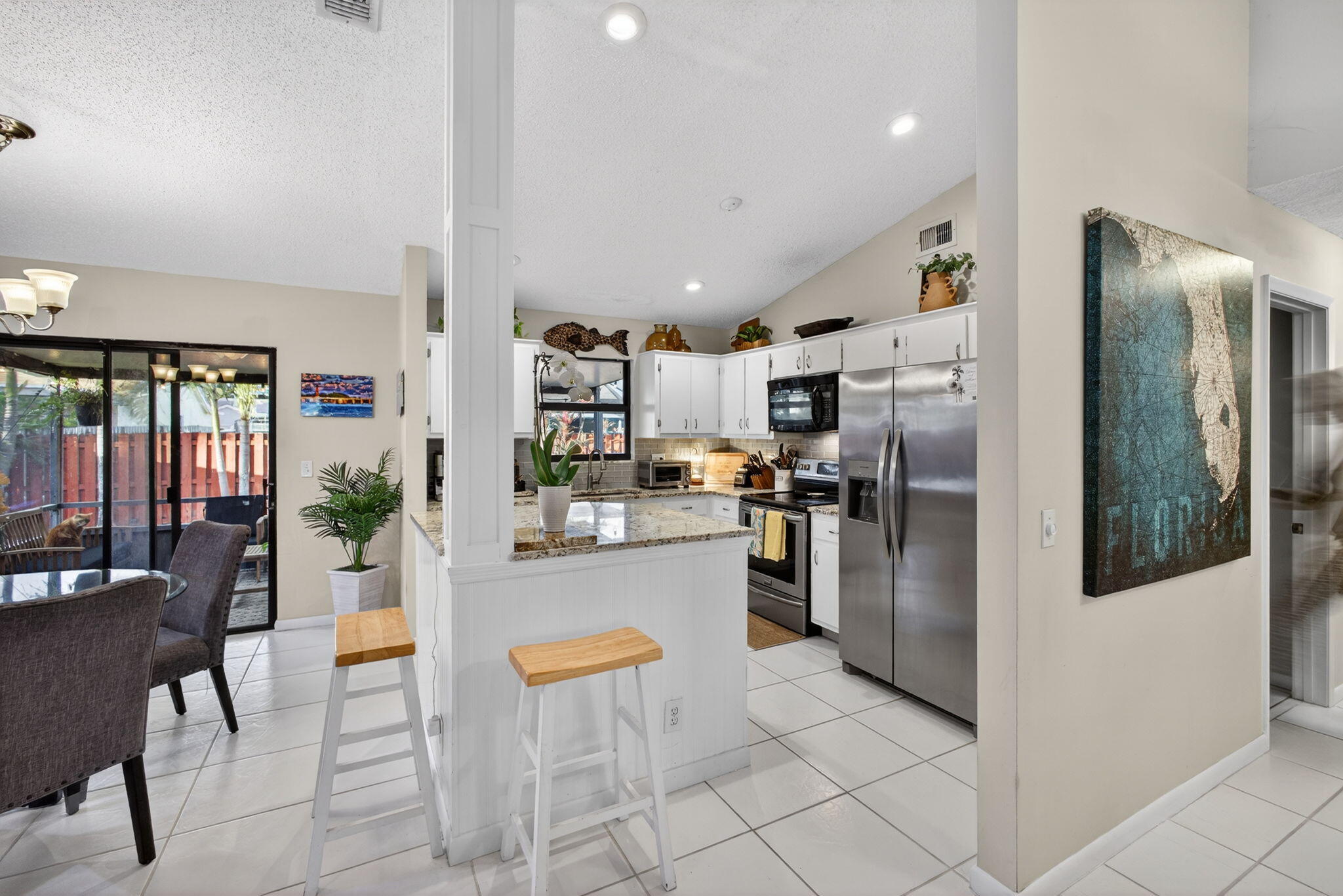 154 Rosewood Circle Jupiter, FL 33458 - Photo 18 of 43 a kitchen with stainless steel appliances granite countertop a refrigerator and a stove top oven