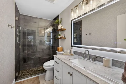 a kitchen with stainless steel appliances granite countertop a sink a stove counter space and a window