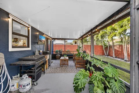 a living room with patio furniture and a floor to ceiling window