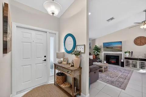 a living room with furniture a fireplace and a dining table with wooden floor