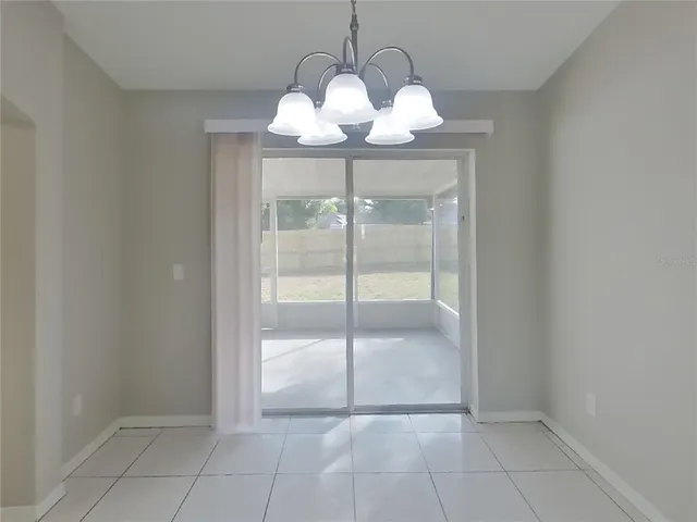 a view of a room with a chandelier fan and glass door