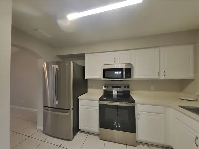 a kitchen with stainless steel appliances a refrigerator stove and microwave