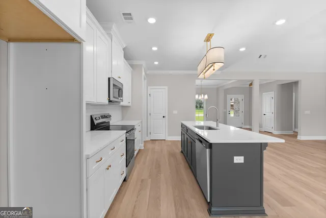 a large kitchen with stainless steel appliances kitchen island granite countertop a stove and a sink