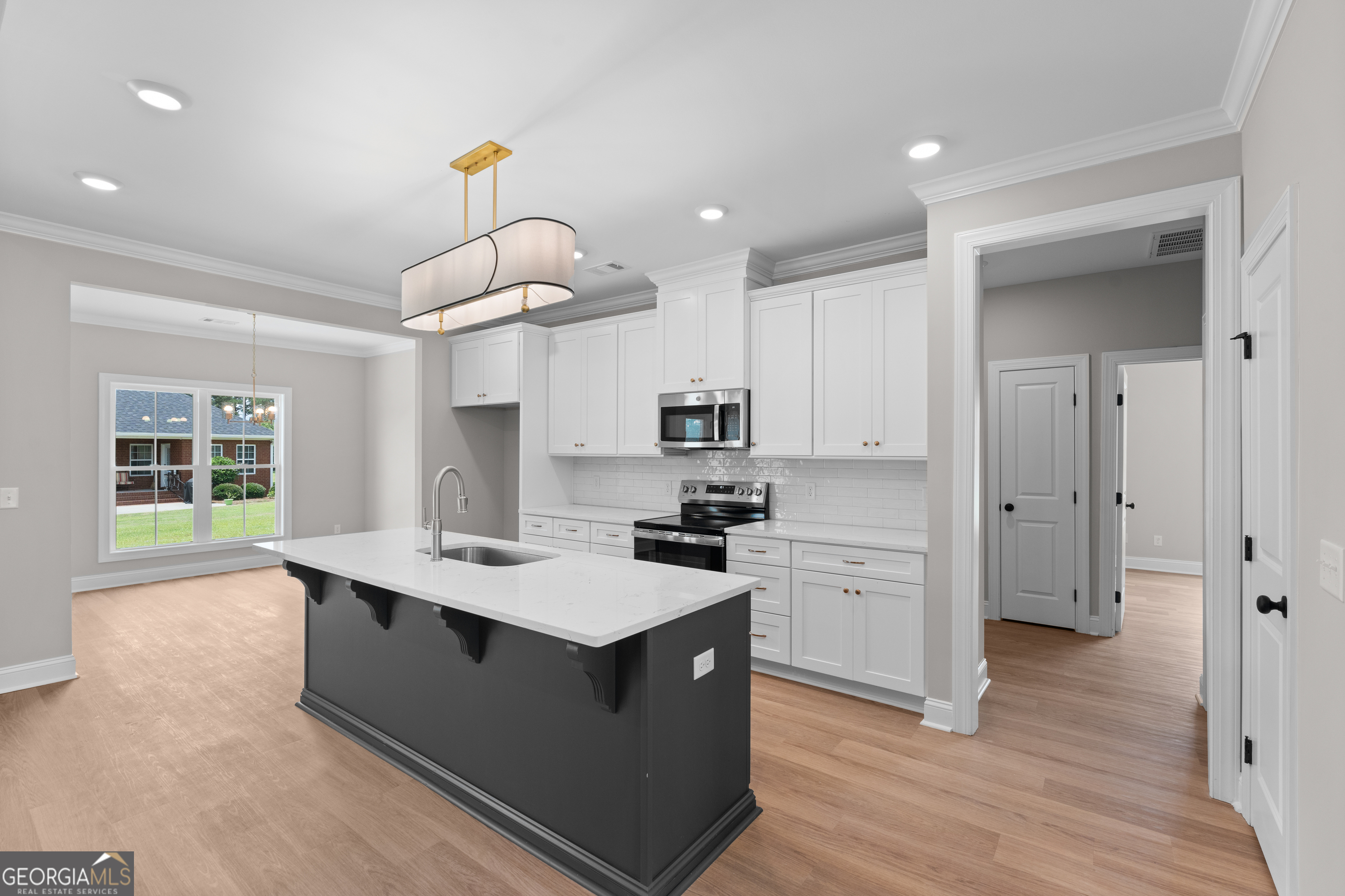 10 Honeysuckle Drive Claxton, GA 30417 - Photo 16 of 42 a kitchen with stainless steel appliances a sink a stove a refrigerator cabinets and wooden floor
