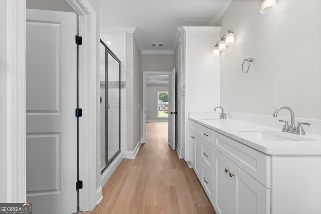 a spacious bathroom with a double vanity sink and mirror