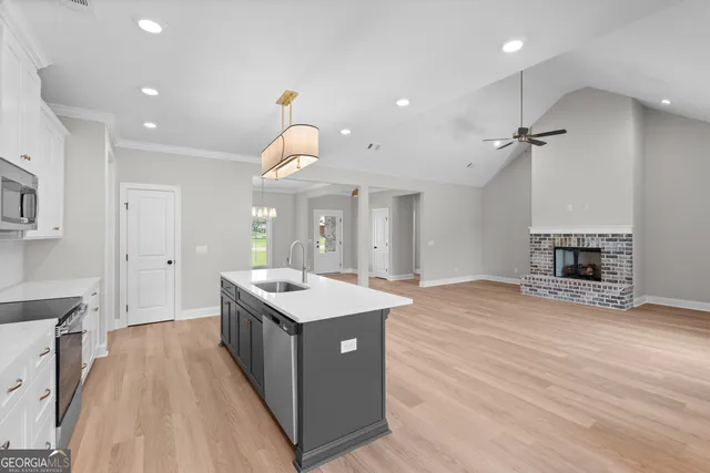 a large kitchen with kitchen island a sink stainless steel appliances and cabinets