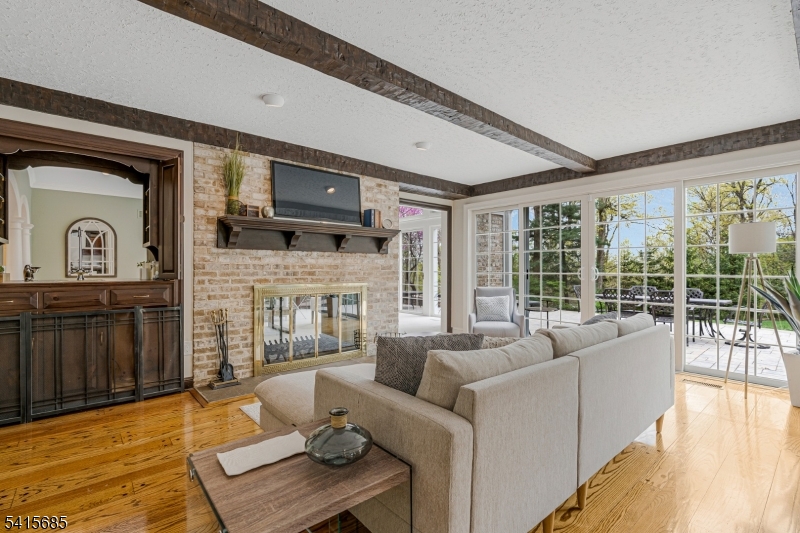 167 Ridge Road Watchung, NJ 07069 - Photo 12 of 50 a living room with furniture a fireplace and a floor to ceiling window