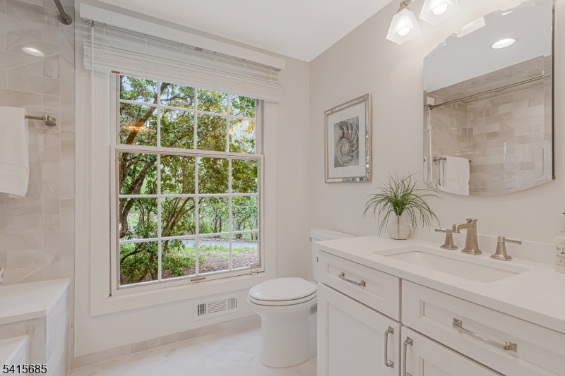 167 Ridge Road Watchung, NJ 07069 - Photo 31 of 50 a bathroom with a toilet a sink a large mirror and next to a window