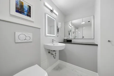 a bathroom with a sink a toilet and mirror
