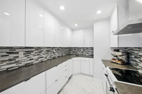 a kitchen with granite countertop a stove and a sink