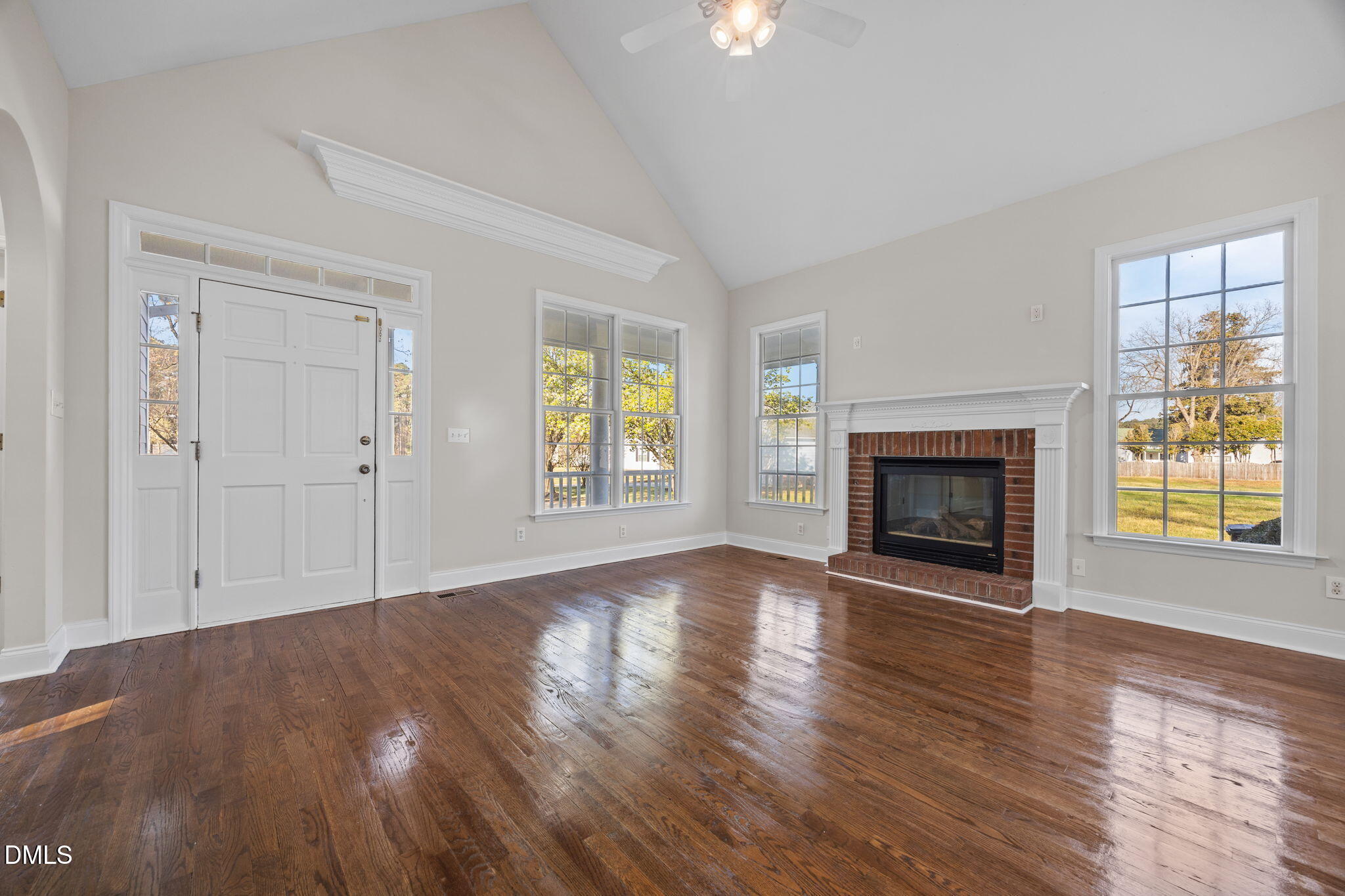 118 Kayleigh Court Willow Spring, NC 27592 - Photo 8 of 37 an empty room with wooden floor fireplace and windows