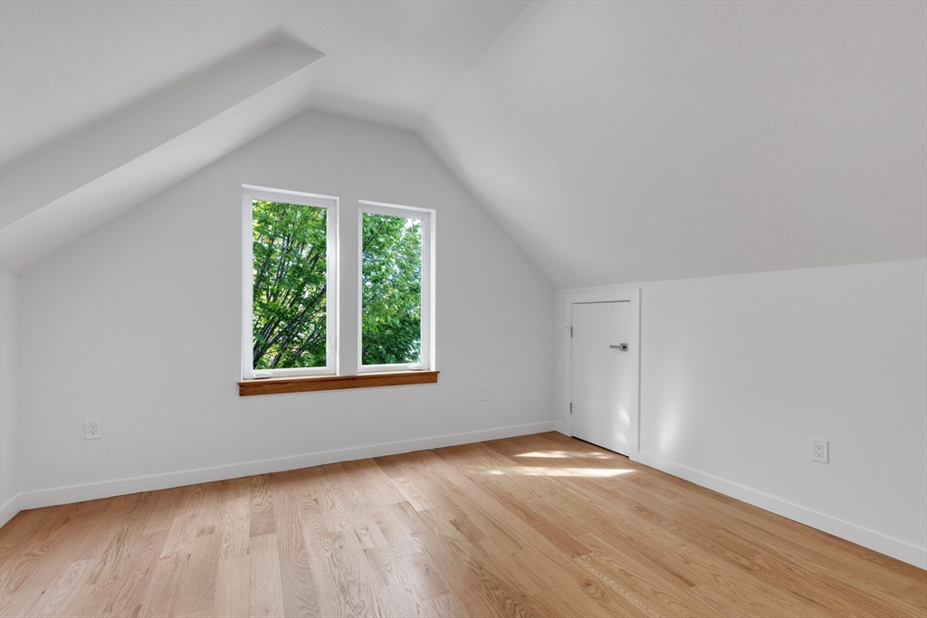69 Boston Avenue, Unit 69 Somerville, MA 02144 - Photo 14 of 26 an empty room with wooden floor and windows