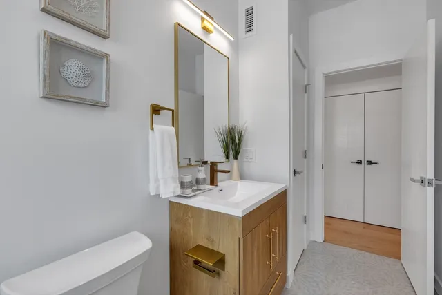 a bathroom with a sink mirror vanity and toilet