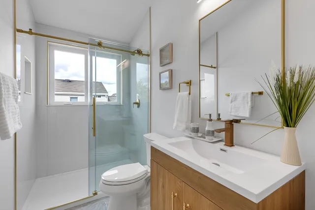 a bathroom with a sink a toilet and a large mirror